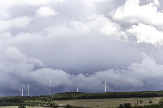 Champ d'éoliennes sur ciel orageux